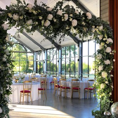 Arche de mariage pour cérémonie laïque et accueil des invités dans une salle de réception